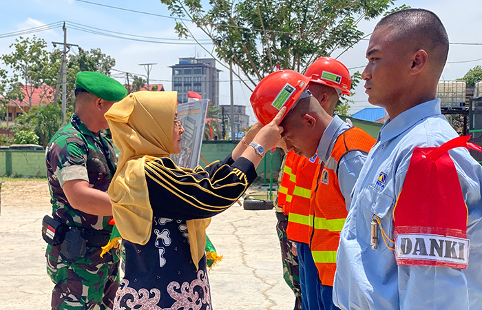 PENUTUPAN BINTALSIK: Bupati Berau Sri Juniarsih, saat menyerahkan helm kepada perwakilan peserta magang, sebagai tanda ditutupnya pelatihan Bintalsik Bela Negara oleh PT Pamapersada Nusantara.