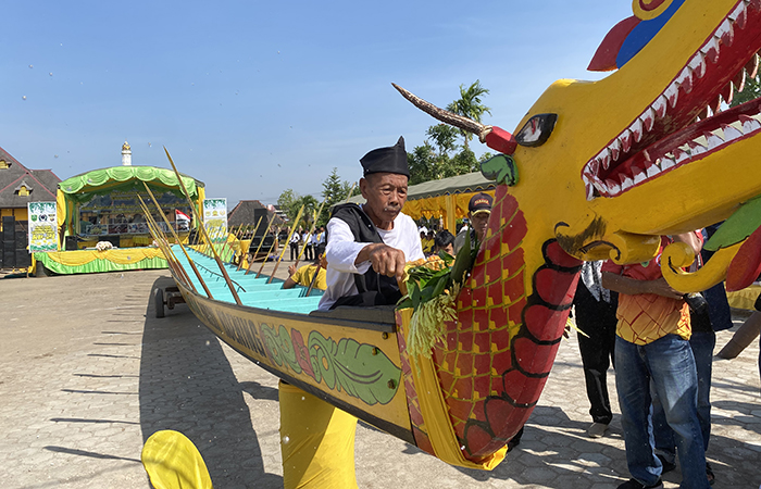 PERTAHANKAN TRADISI: Sesaat sebelum prosesi mengangkat Perahu Panjang dalam acara Baturunan Parau, sesepuh adat membacakan doa dan melempari perahu dengan beras kuning.