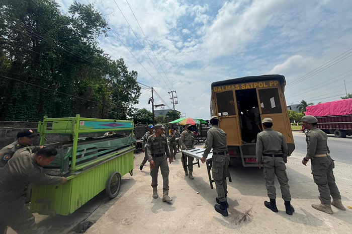 PENERTIBAN: Personel Satpol PP Berau melakukan penertiban rombong dan kursi pedagang di Jalan HARM Ayoeb, tepatnya di depan Pasar Sanggam Adji Dilayas beberapa waktu lalu.