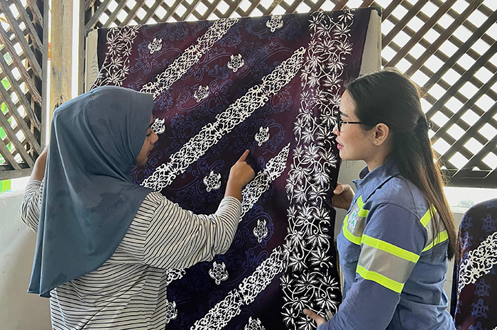 PERHATIKAN: Manajemen BUMA Lati memperhatikan salah seorang warga yang menjelaskan motif batik penyu pada kain yang akan dipasarkan.