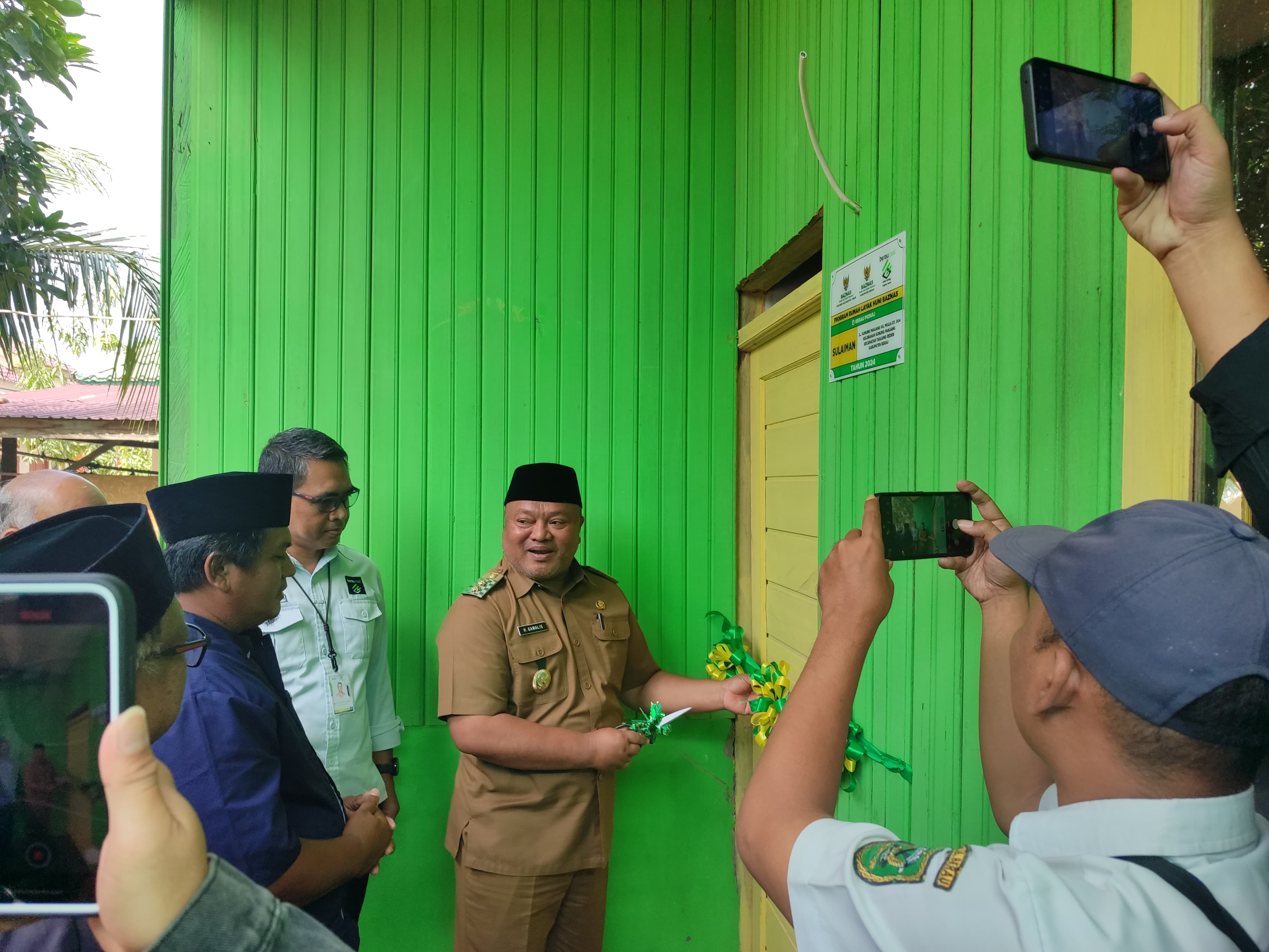 SERAHKAN RLH: Wakil Bupati Berau Gamalis secara simbolis menyerahkan RLH kepada lima mustahik yang mendapat bantuan di Kelurahan Gunung Panjang, Tanjung Redeb, kemarin. (SENO/BP)