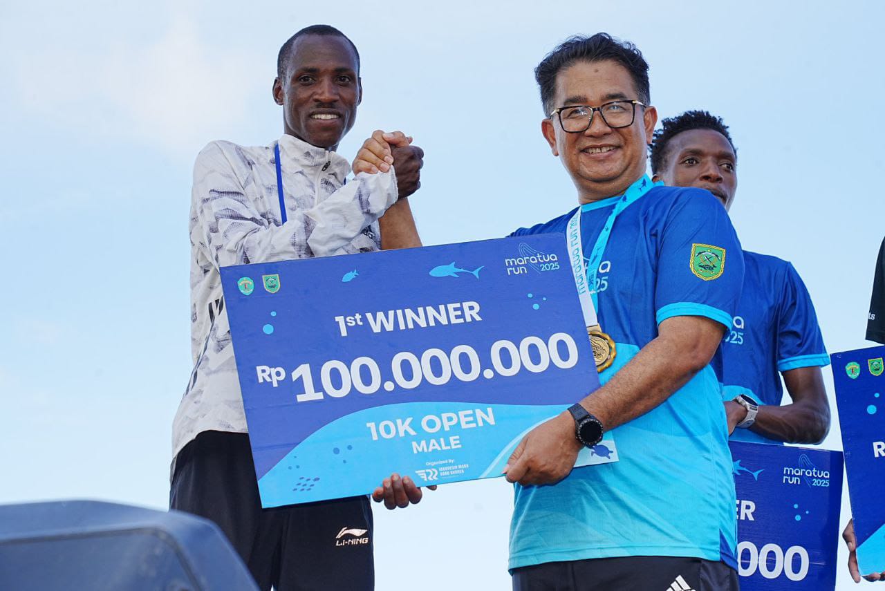 JUARA: Pemenang kategori 10k internasional putra William Nyarondia Morwabe menerima hadiah uang Rp 100 juta dari Pj Gubernur Kaltim Akmal Malik. (ALMAN/ADPIMPROV KALTIM