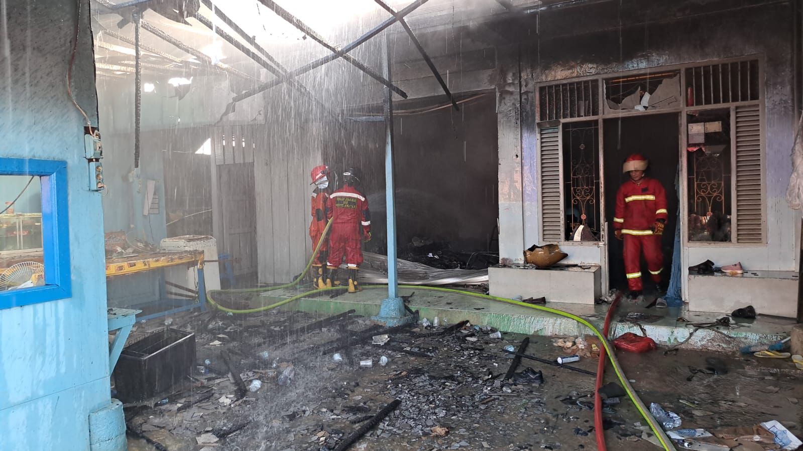 HANGUS: Tim dari BPBD Berau saat melakukan pendinginan di lokasi kebakaran di Jalan Gatot Soebroto, Sabtu (15/3). (ARTA KUSUMA YUNANDA/BP)