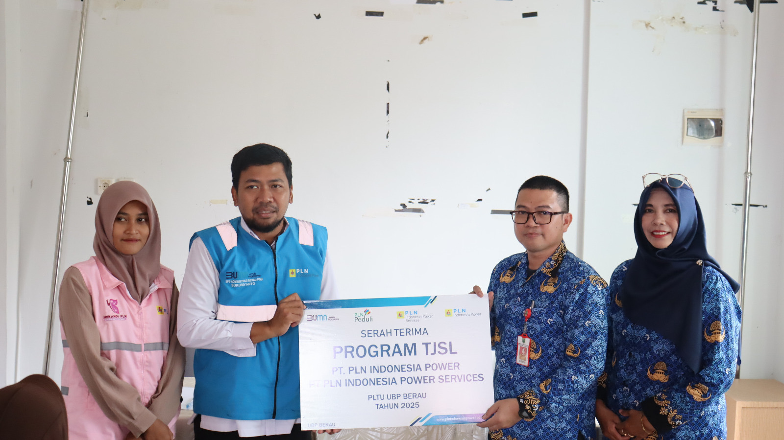 SIMBOLIS: SPS Administrasi PLN IP UBP Berau, Sukuriyanto didampingi perwakilan srikandi  Sintia Adi Permata menyerahkan bantuan secara simbolis kepada Lurah Teluk Bayur Ade Ananda. (PLN IP UBP BERAU)