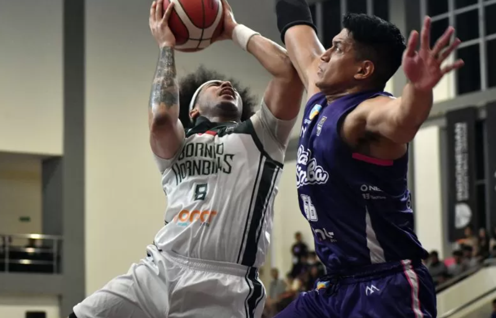 Pebasket RANS Simba Bogor Galank Gunawan (kanan) berusaha mengadang pemain Borneo Hornbills Xavier Ford. (ANTARA)