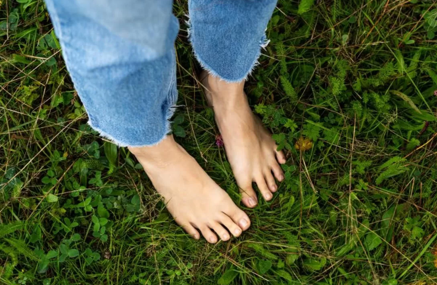 Ilustrasi seseorang yang berjalan tanpa alas kaki di atas rumput. (Freepik)