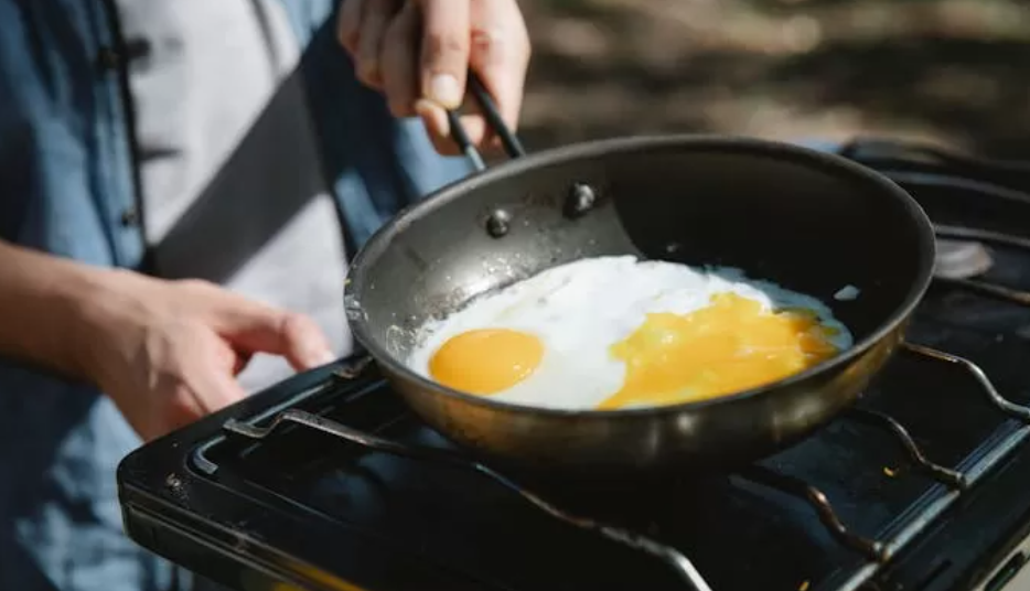 Seseorang sedang memasak telur, salah satu sumber protein (Dok. Pexels)