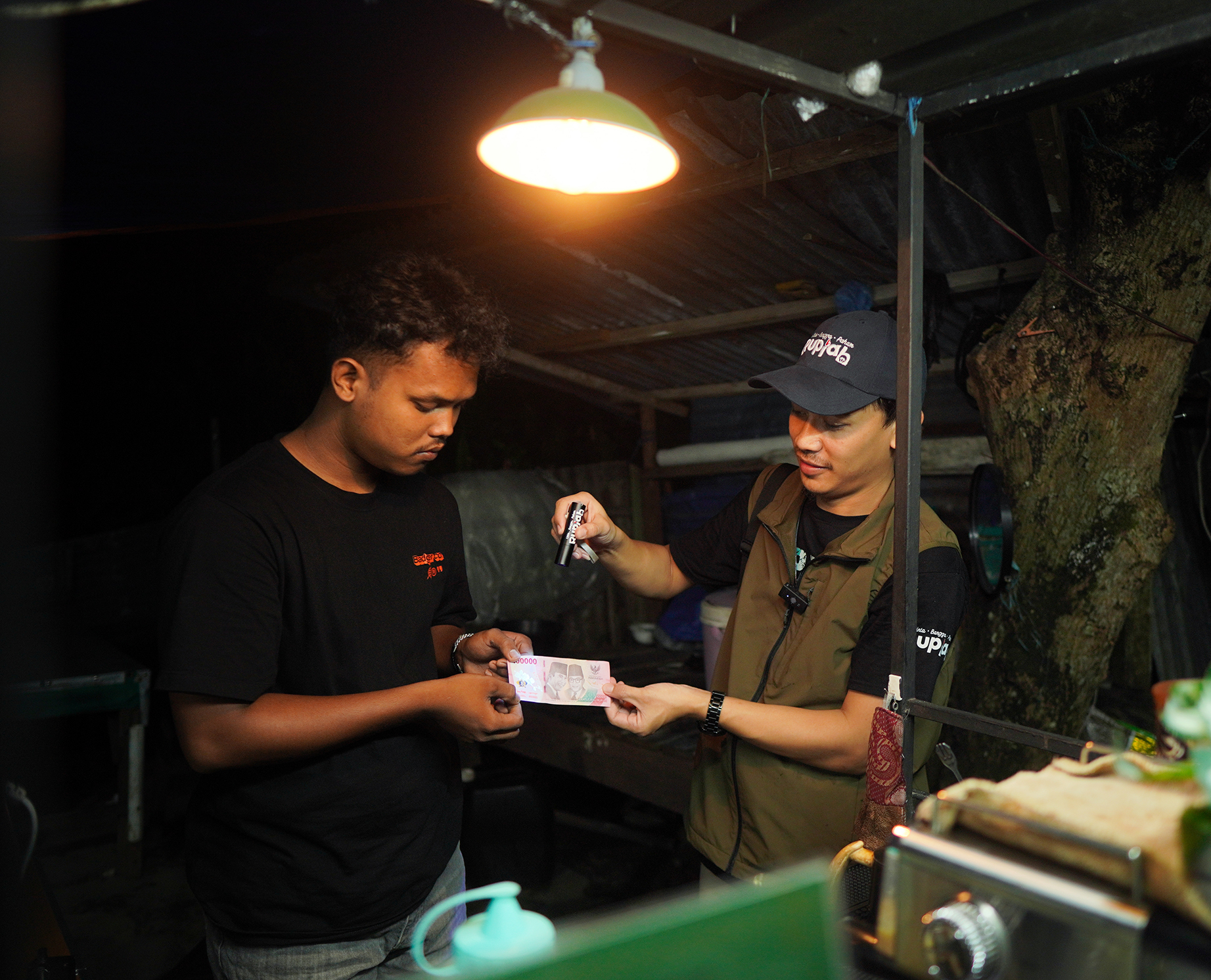 SOSIALISASI KEASLIAN UANG: Petugas KPwBI Kaltara sosialisasi keaslian uang ke pedagang kaki lima, Sabtu (17/5). (KPWBI KALTARA UNTUK HRK)