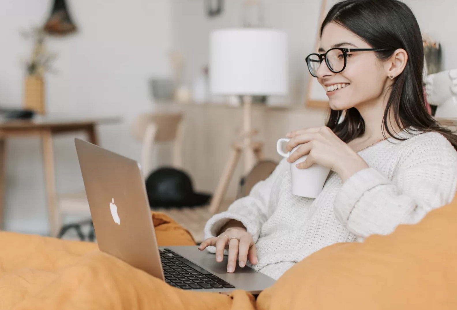Seorang pekerja mengetik di laptop sambil minum kopi, menggambarkan produktivitas di luar jam kerja utama. (Dok. Canva)