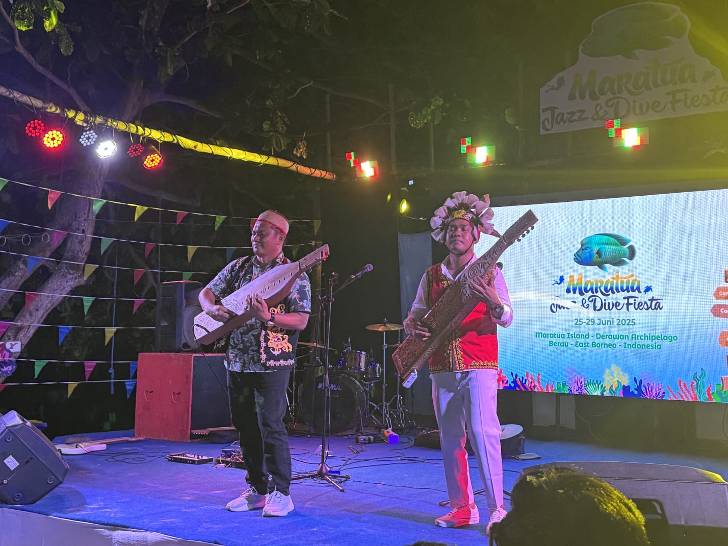 MERIAH: Penampilan Anggota Komisi II DPRD Berau, Gideon bersama dengan musisi Berau, Whansetyawan bermain alat musik Sape di festival Maratua Jazz and Dive Fiesta. (DAYAT/BP)