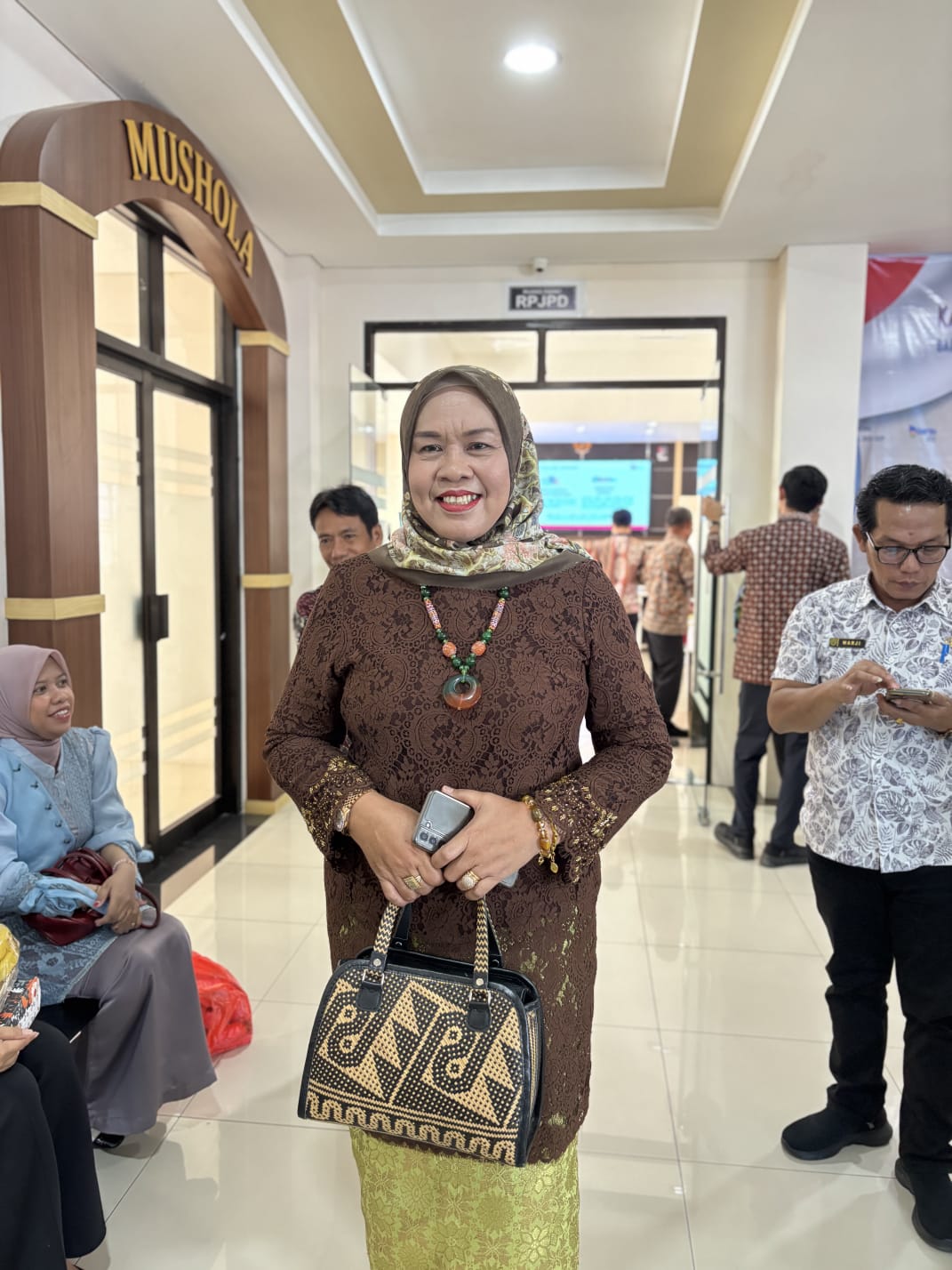 ILUSTRASI: Kepala Diskoperindag Berau Eva Yunita saat memakai salah satu produk tas rotan karya pengrajin lokal. (IZZA/BP)