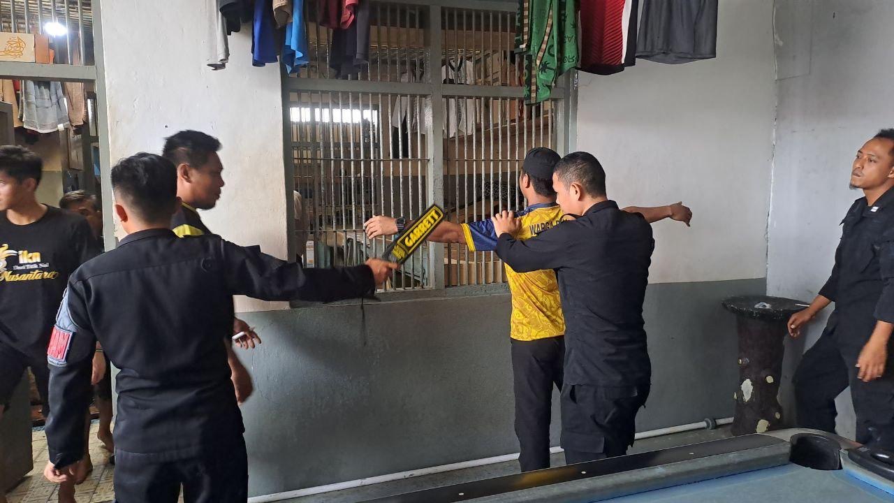 LAKUKAN PEMERIKSAAN: Petugas Rutan Tanjung Redeb saat melakukan penggeledahan terhadap warga binaan. (ARTA KUSUMA YUNANDA/BP)