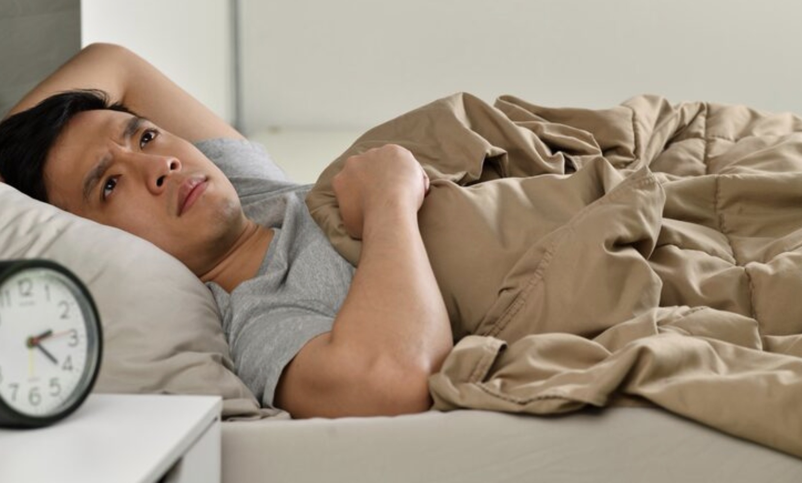 Seseorang yang mengalami kesulitan tidur di malam sebelum penerbangan pagi (Freepik)