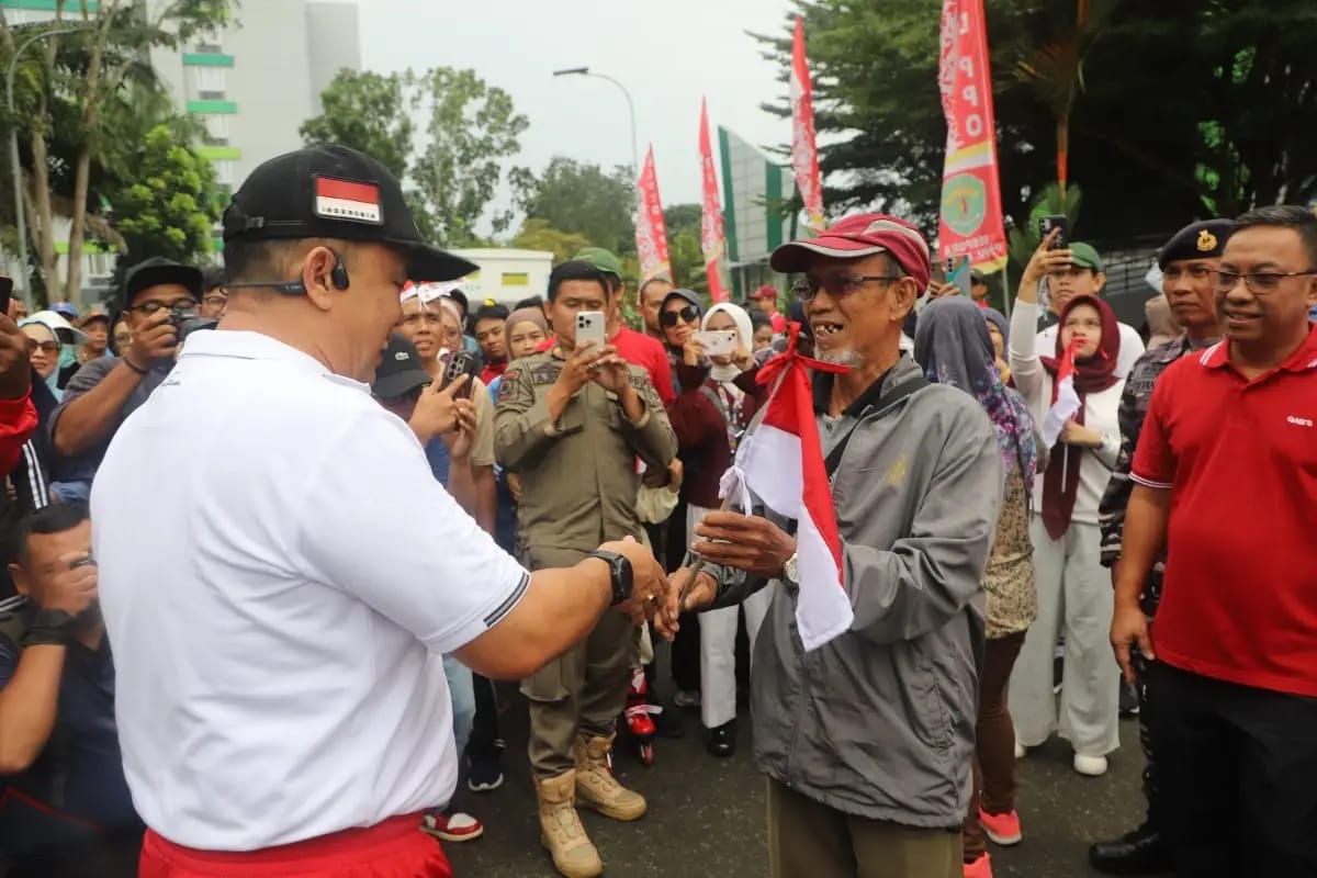 JELANG KEMERDEKAAN: Jajaran Pemprov Kaltin membagikan bendera Merah Putih ke masyarakat. (DISKOMINFO KALTIM UNTUK BERAU POST)