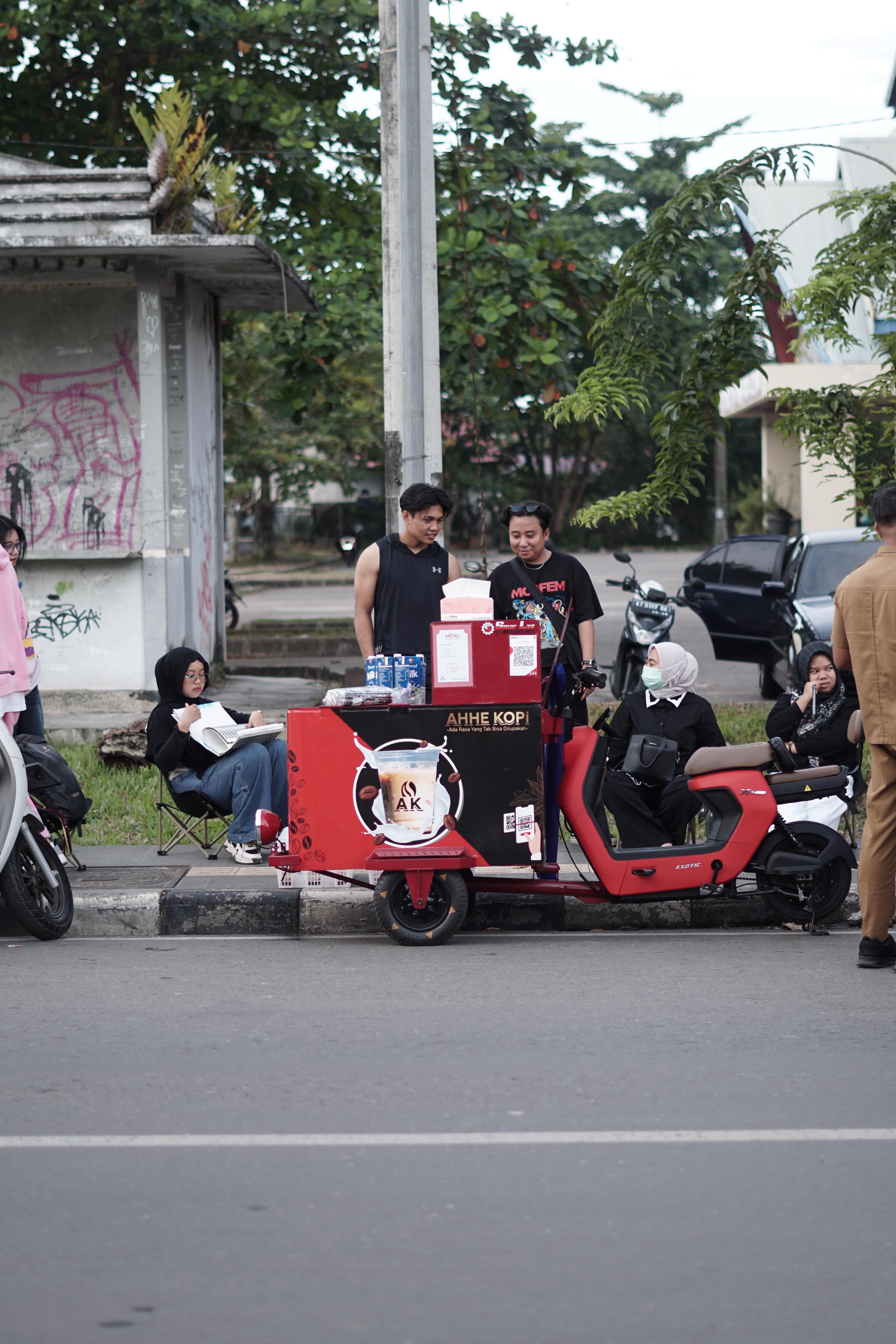 BERDAGANG: Pembeli antre untuk membeli kopi yang dijual Fatur di kawasan Jalan Mangga I. (DAYAT/BP)