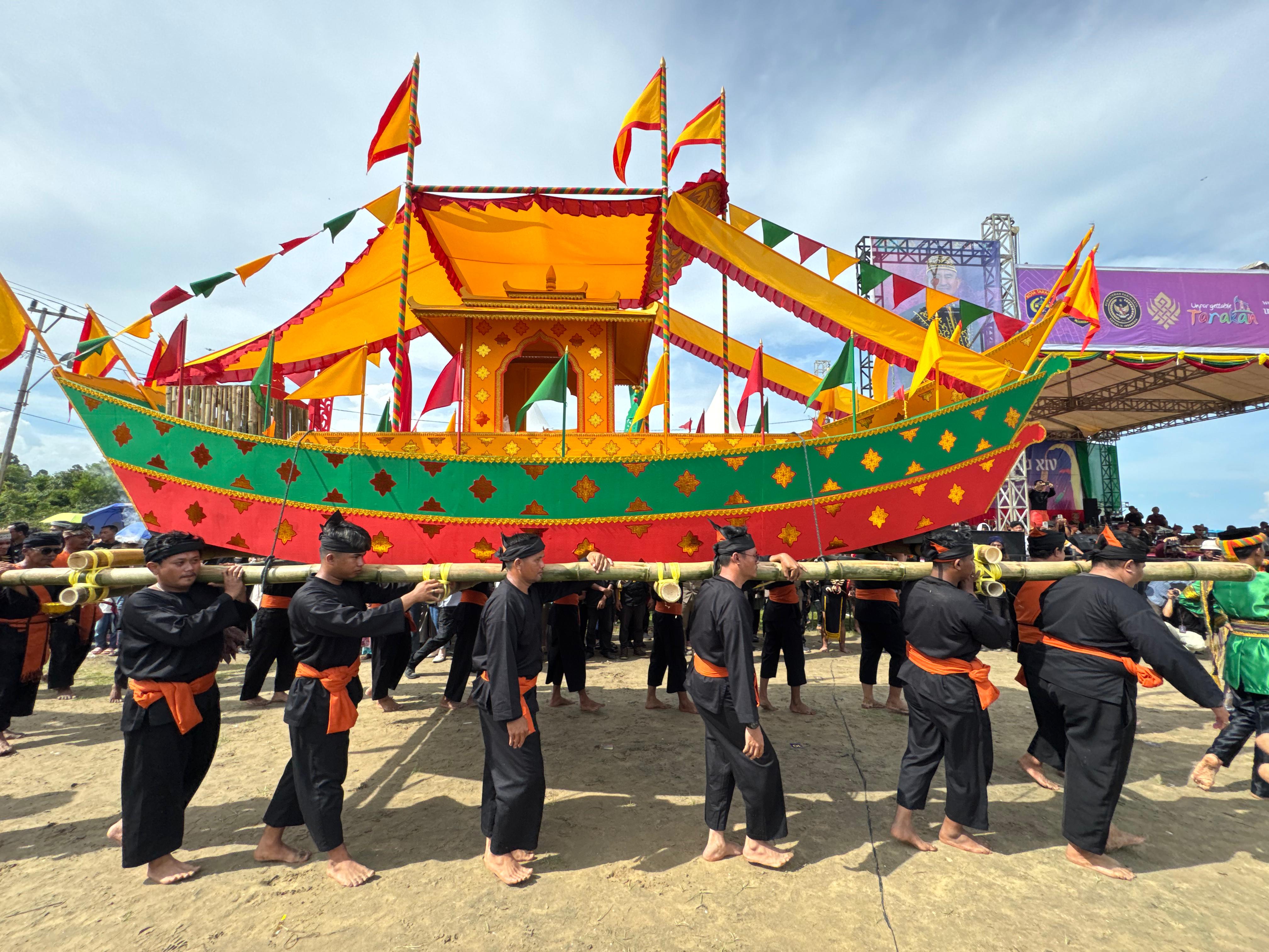 PADAW TUJU DULUNG: Tokoh adat memikul perahu padaw tuju dulung sebelum dilarungkan ke pantai Ratu Intan, Minggu (12/10). (SEPTIAN ASMADI/HRK)