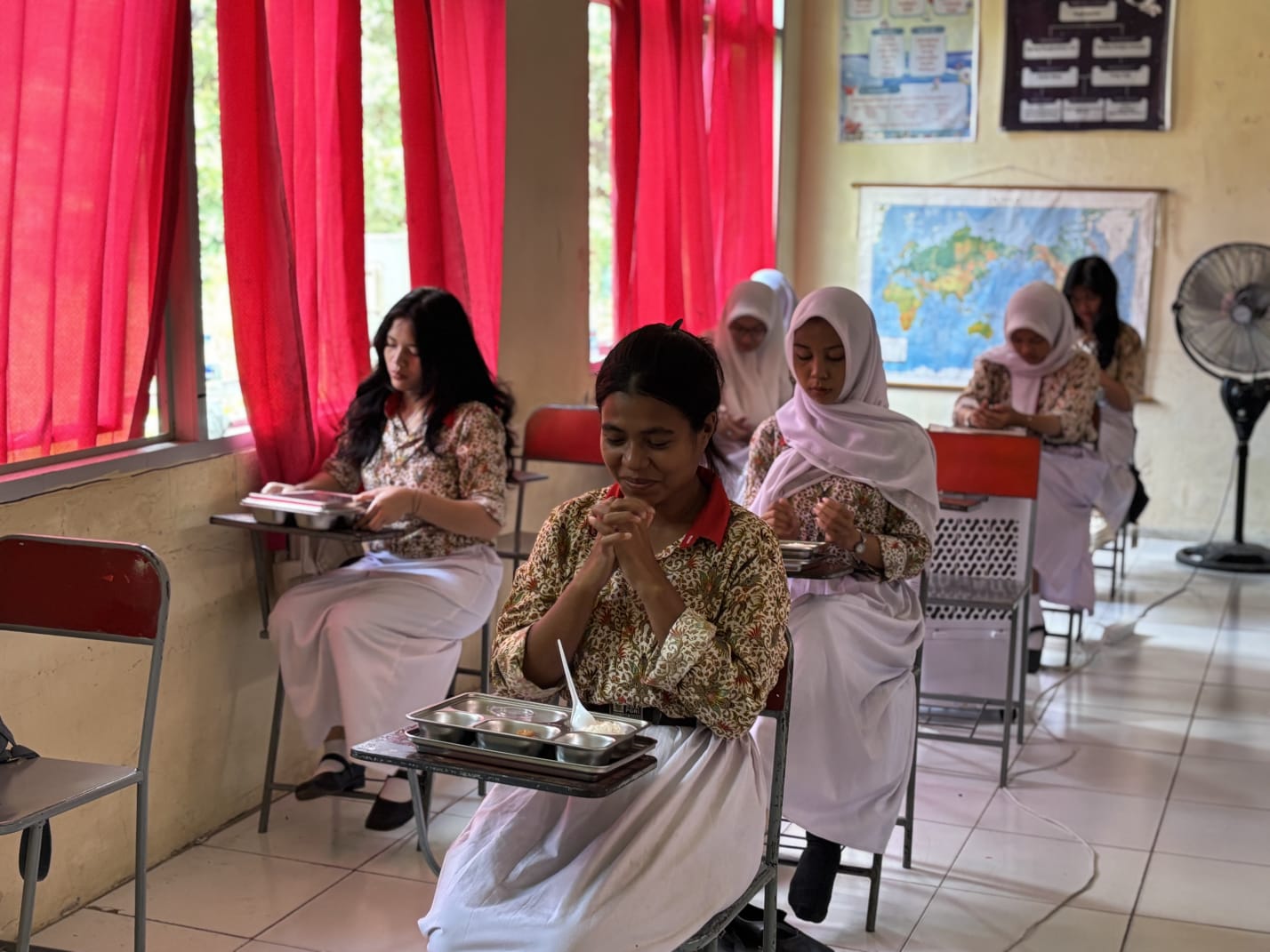 HARUS HIGIENIS: Para pelajar tengah berdoa sebelum mengonsumsi MBG. Kualitas kesehatan makanan pun diminta harus selalu diperhatikan. (IZZA/BP)