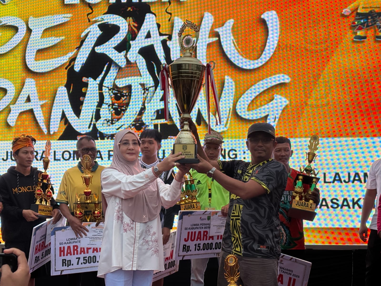 LOMBA TRADISIONAL: Bupati Berau Sri Juniarsih saat memberikan hadiah kepada pemenang lomba perahu panjang tradisional tahun 2025, Mambas Parrang dari Kecamatan Sambaliung. (IZZA/BP)