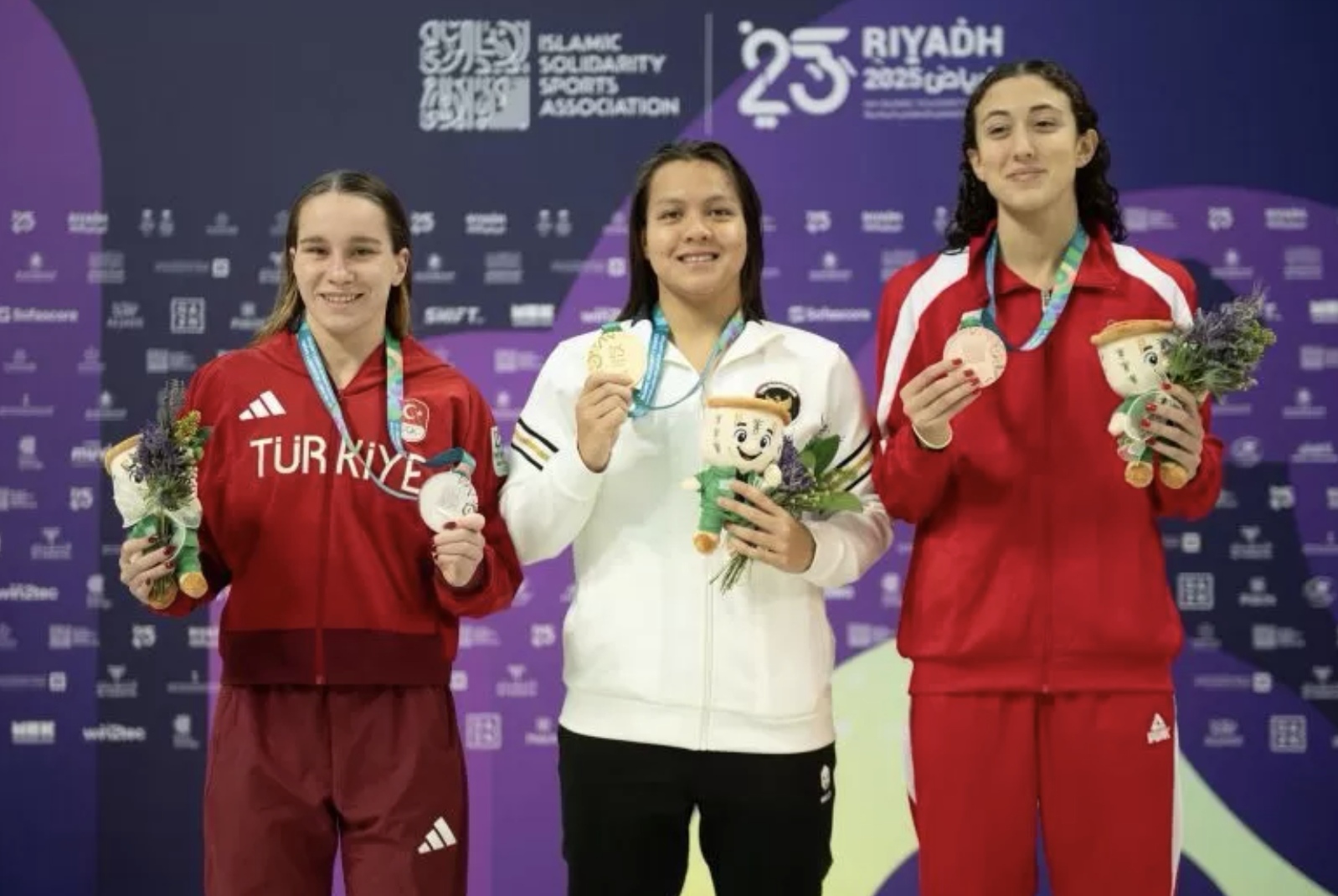 Perenang Indonesia Adelia (tengah) meraih medali emas dalam ajang Islamic Solidarity Games (ISG) Riyadh 2025 di Riyadh, Arab Saudi, Sabtu (9/11/2025). (KOI/Mochammad Rifqi Priadiansyah)