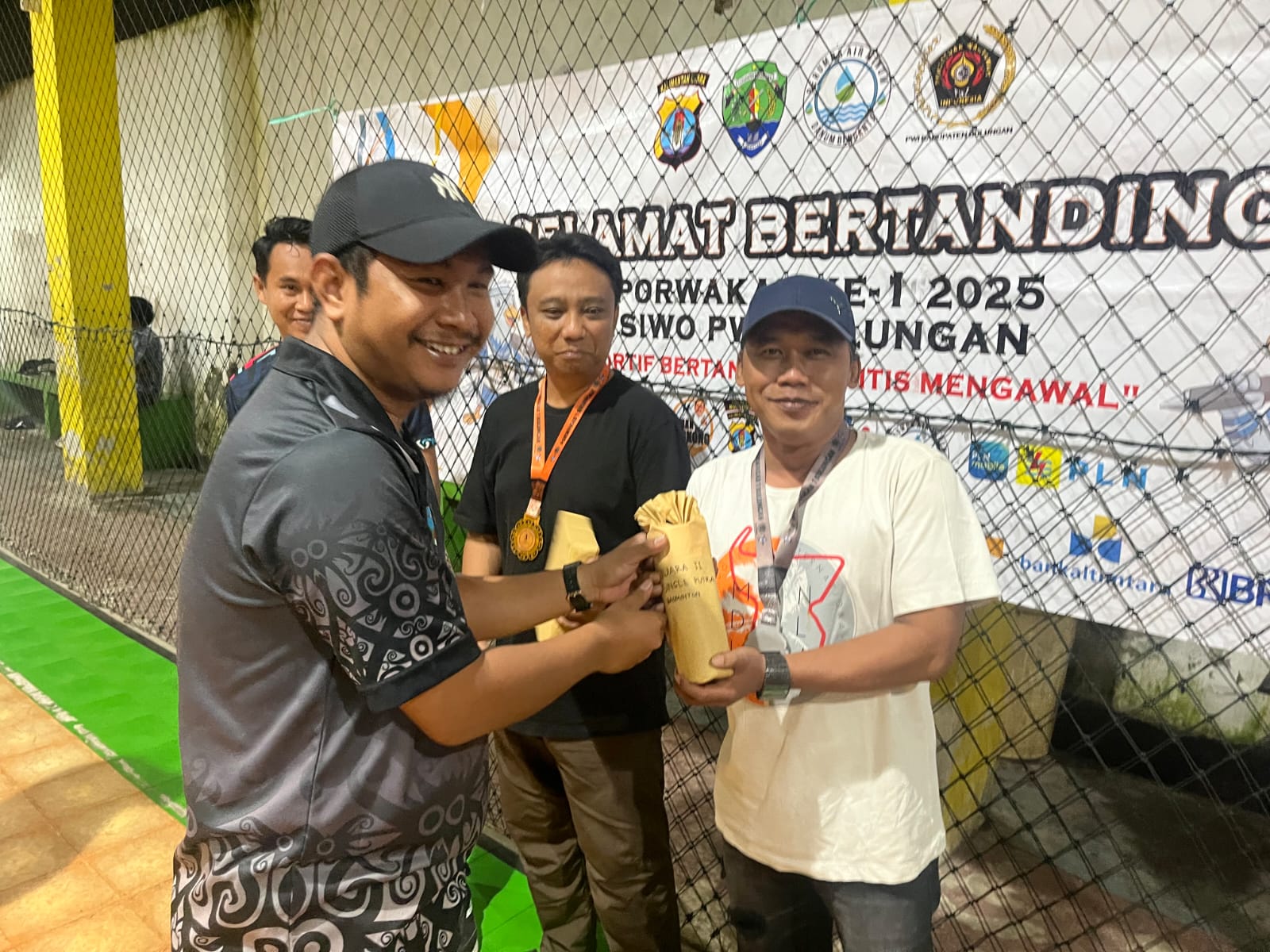 PORWAKAB: Ketua SIWO PWI Kaltara Eliazar Simon menyerahkan hadiah kepada Ipunk juara II badminton single putra. (FAISAL/HRK)