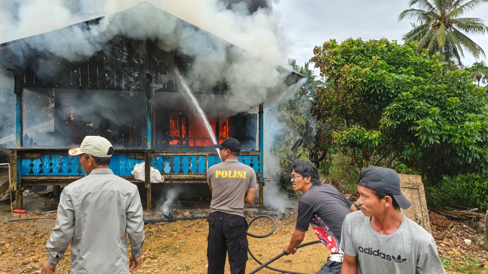 PEMADAMAN: Tim dari BPBD, pihak kepolisian dan masyarakat saat berijibaku memadamkan api di rumah milik Jhon yang terbakar kemarin. (ARTA KUSUMA YUNANDA/BP)