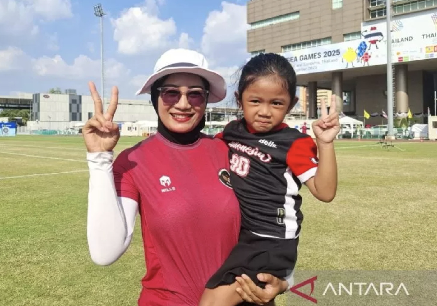 Atlet panahan peraih medali emas SEA Games 2025 Diananda Choirunisa berfoto bersama putri pertamanya usai bertanding di lapangan sepakbola SAT Bangkok, Rabu (17/12/2025). (ANTARA/Aditya Ramadhan)