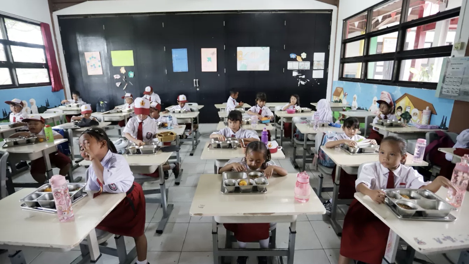 Sejumlah murid menyantap Makan Begizi Gratis (MBG) di SDN Pulau Kelapa 01 Pagi, Kepulauan Seribu, Jakarta, Kamis (4/12/2025). (Dery Ridwansah/ JawaPom.com)