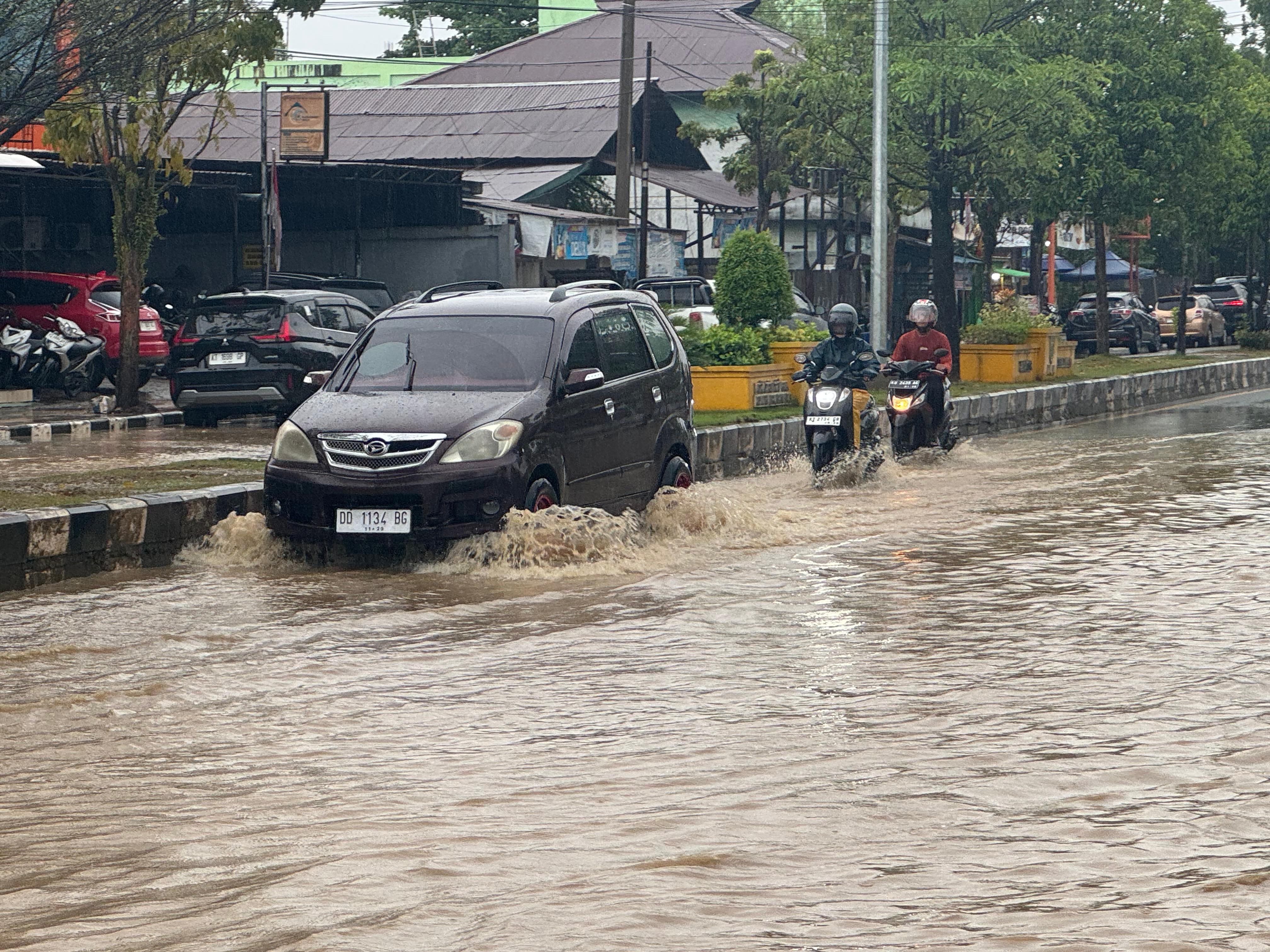 TERJANG BANJIR: Sejumlah kendaraan bermotor berusaha menerobos banjir, beberapa titik di Jalan Gatot Subroto terpantau mengalami banjir yang cukup menghambat laju kendaraan. (SENO/BP)