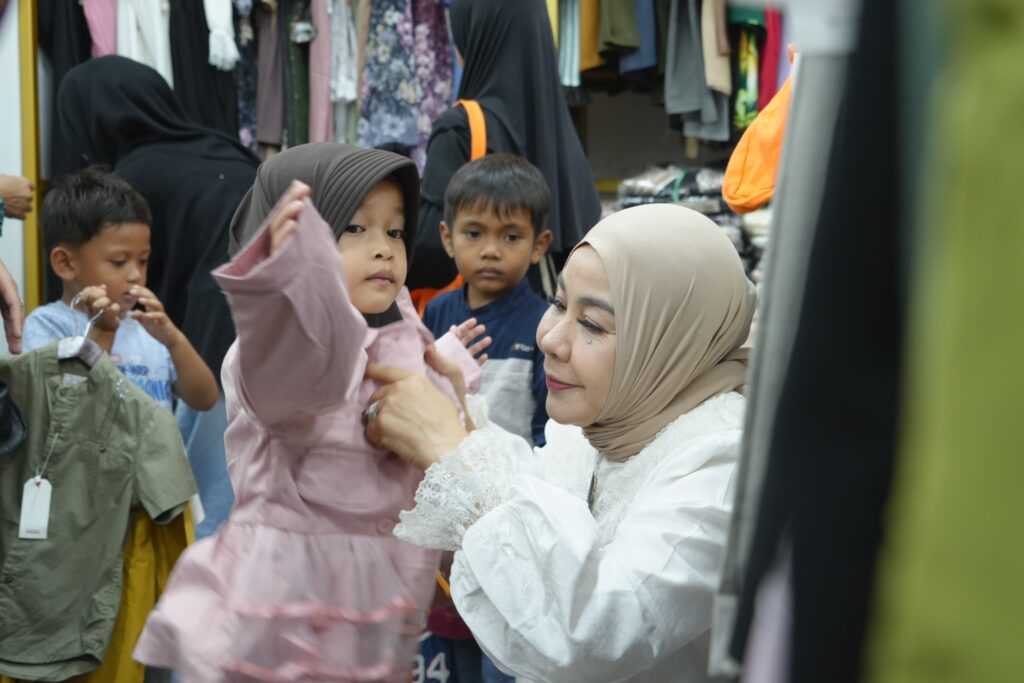BELANJA BERSAMA: Ketua TP PKK Kaltara, Rahmawati Zainal mendampingi anak-anak memilih pakaian dan perlengkapan Hari Raya Idulfitri. (DKISP KALTARA)