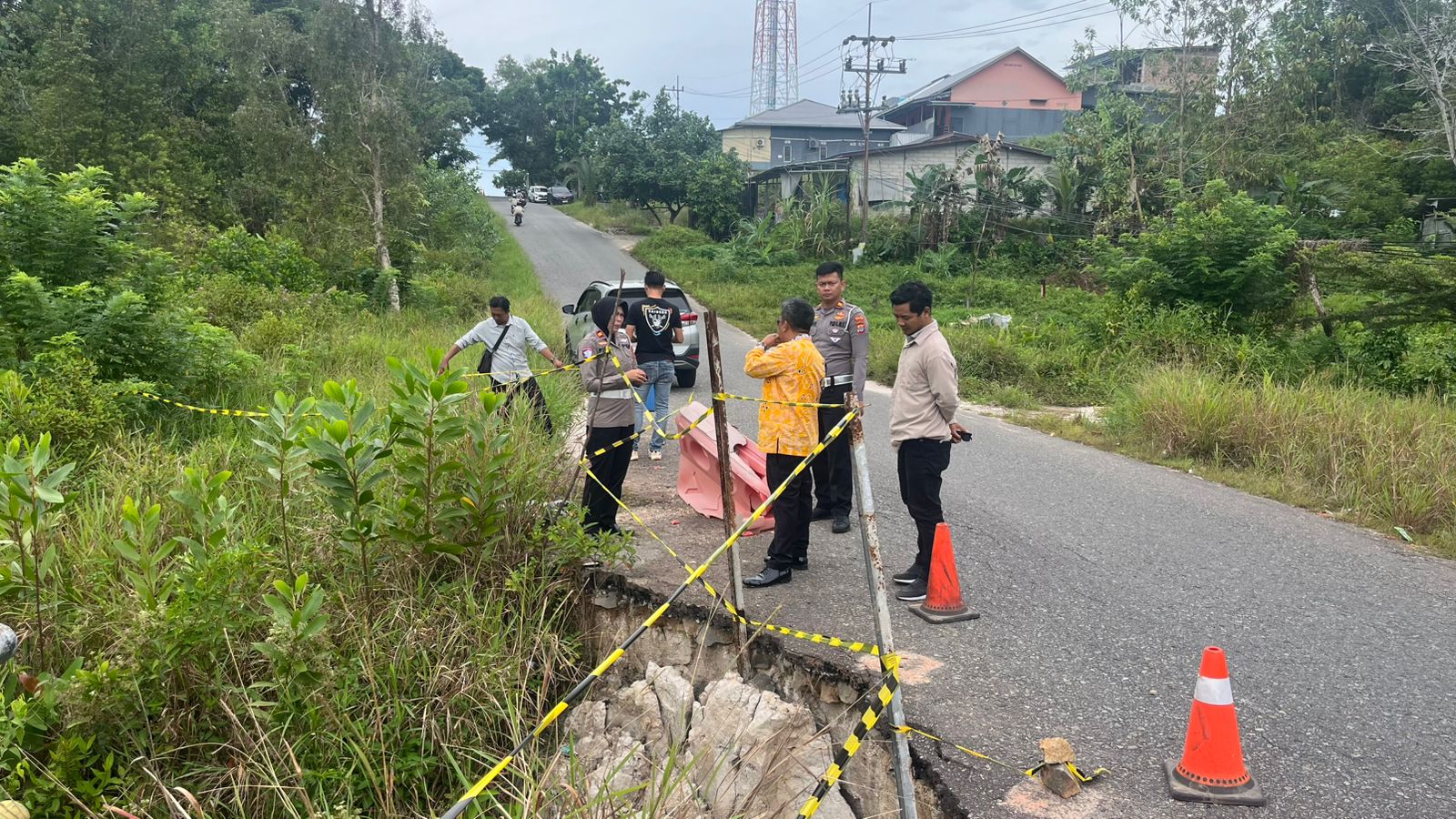 PERLU DIANTISIPASI: Personel Polres Tarakan meninjau kondisi jalan yang longsor menuju Pantai Amal Lama, Jumat (6/3) lalu. (SEPTIAN ASMADI/HRK)