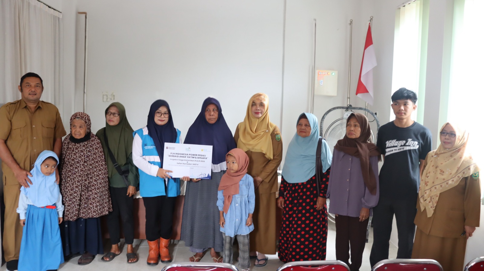 Perwakilan Srikandi PLN Indonesia Power (IP) UBP Berau, Mardiatul Jannah, menyerahkan santunan secara simbolis kepada KASI PU KESOS Kelurahan Teluk Bayur, Rusnah, di Teluk Bayur, Berau.
