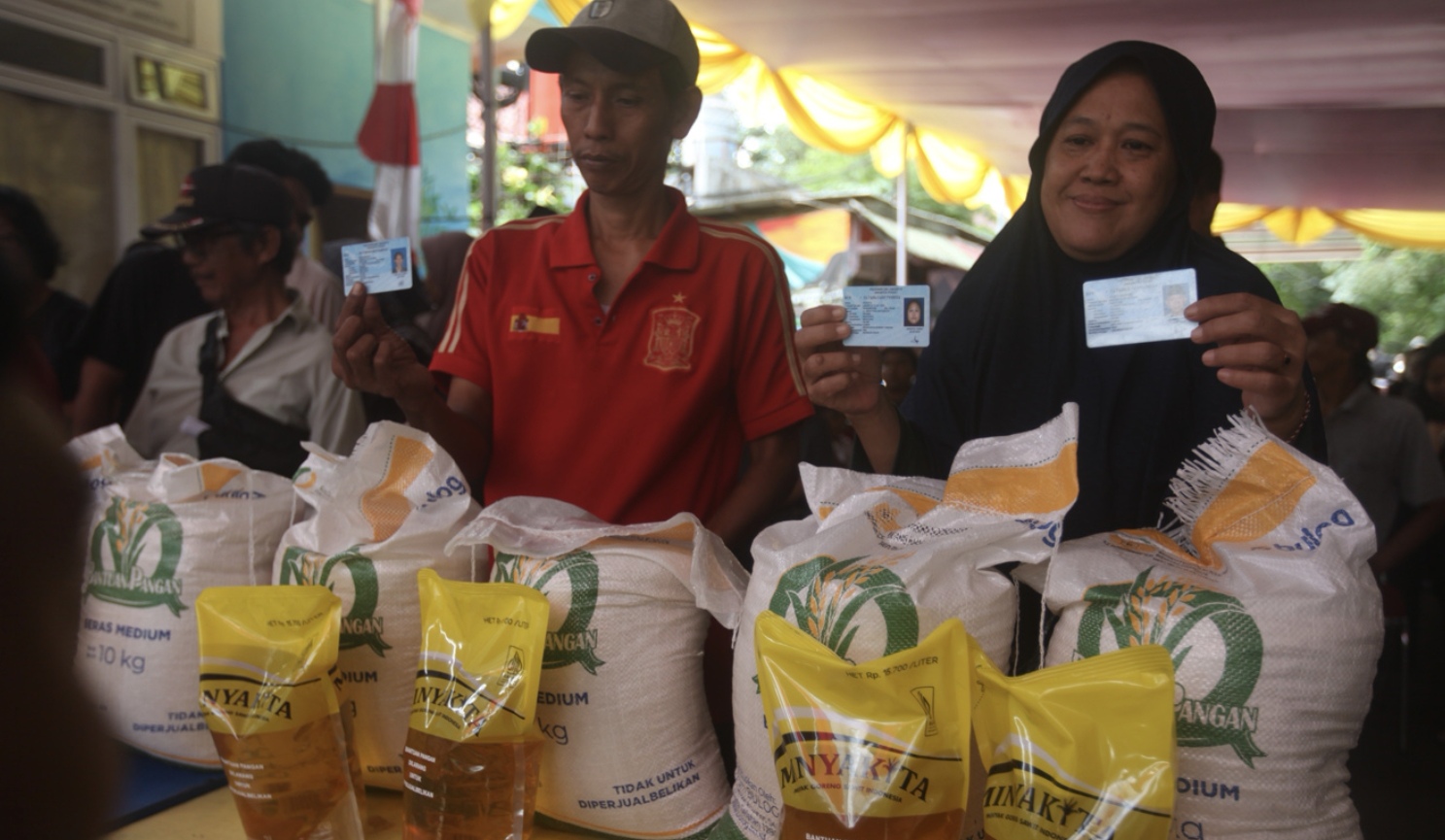 Ilustrasi Warga saat pengambilan bantuan pangan gratis berupa beras dan minyak goreng.