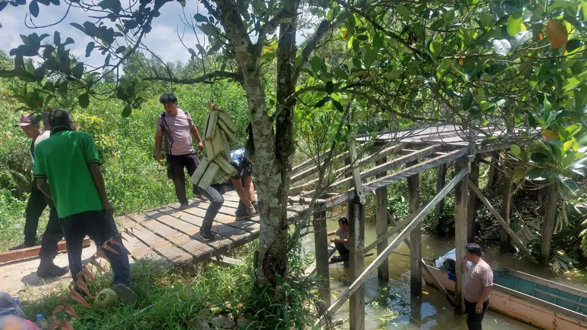 GOYONG-ROYONG: Kapolsek Sambaliung AKP Ridwan Lubis bersama masyarakat Sukan Tengah, merevitalisasi jembatan penghubung Kampung Sukan Tengah dan Kampung Baru, Sambaliung. (KAPOLSEK SAMBALIUNG UNTUK BERAU POST)