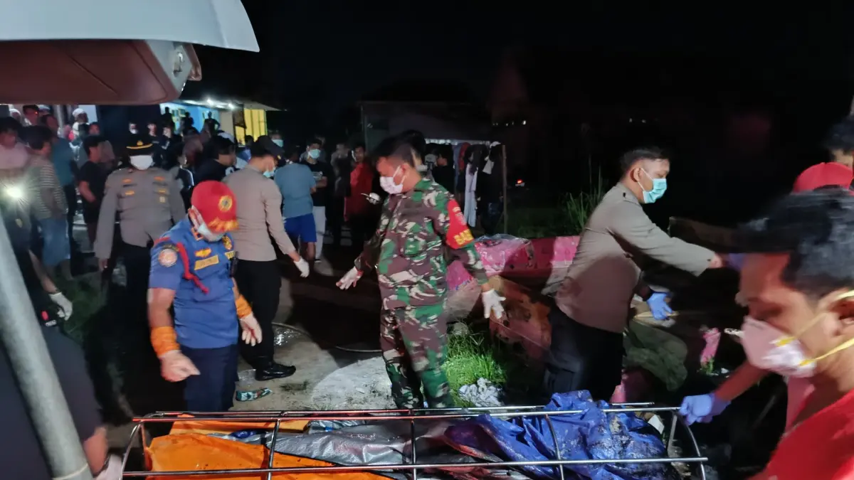 EVAKUASI: Pihak Kepolisian, TNI, PMI dan Disdamkarmat melakukan evakuasi terhadap jasat NW yang ditemukan meninggal di rumahnya. (DISDAMKARMAT UNTUK BERAU POST)