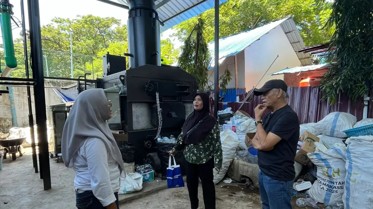 URUSAN SAMPAH: Penulis Bersama motivator pengelolaan sampah di Kelurahan Makassar Baru dengan atar belakang insinerator milik pemkot. (Dokumen pribadi)