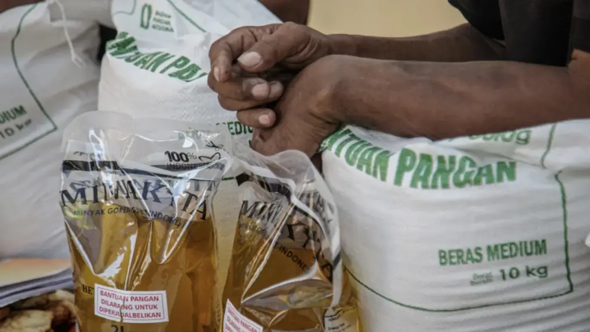 Warga penerima bantuan pangan membawa sejumlah bantuan berupa beras dan minyak goreng saat penyaluran bantuan Keluarga Penerima Manfaat (KPM) di Kantor Kelurahan Batusari, Kota Tangerang, Kamis (14/5/2026). (Hanung Hambara/Jawa Pos)