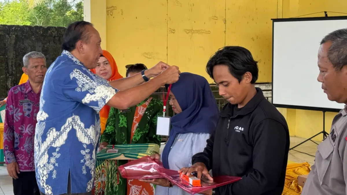 TINGKATKAN KEMAMPUAN: Ketua Umun Dekranasda Berau Edy Siswanto saat mengalungkan tanda peserta, sebagai dimulainya pelaksanaan pelatihan kerajinan berbahan limbah kelapa sejak 29 Mei hingga 2 Juni di Kampung Tanjung Batu. (SENO/BP)