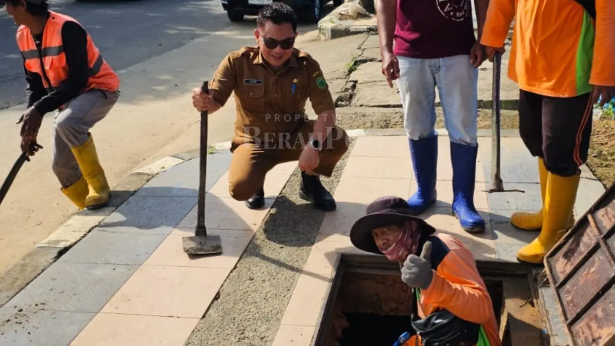 PEMBERSIHAN: Personel DLHK melakukan pembersihan di drainase. (ARTA KUSUMA YUNANDA/BP)