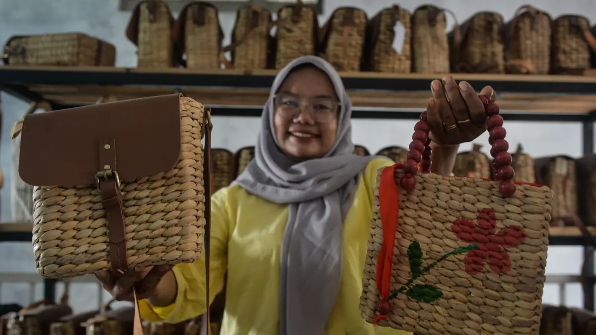 Perajin Ieko Damayanti menunjukkan produk kerajinan tas yang terbuat dari bahan eceng gondok di Pinang, Kota Tangerang, Banten.