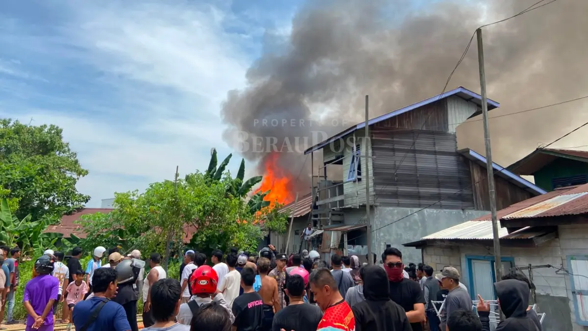 KEBAKARAN GUNUNG PANJANG: Petugas Disdamkarmat Berau berjibaku memadamkan api yang melahap bangunan rumah warga di Jalan Gunung Panjang, Tanjung Redeb, pada Minggu (12/7) siang. Penyebab kebakaran masih dalam penyelidikan.(ARTA KUSUMA YUNANDA/BP)