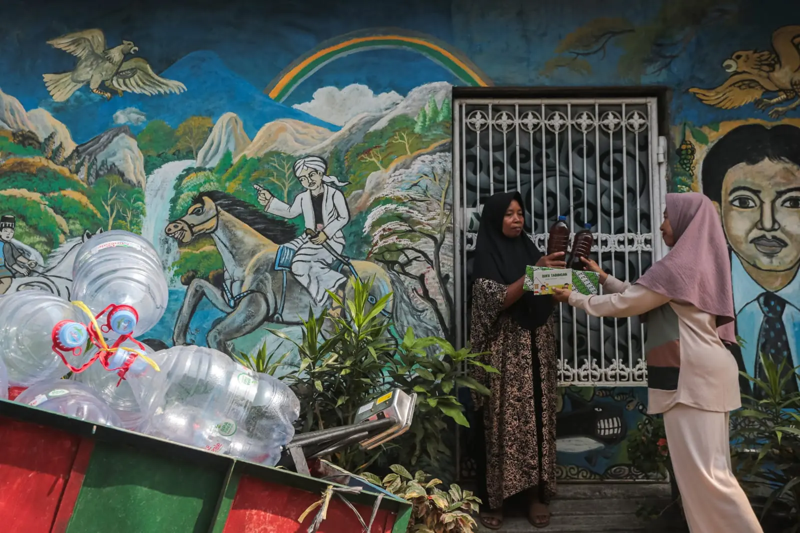 PROSES PENGAMBILAN: Ketua Bank Sampah MATA Amaliyah Sholihah (kanan) menerima setoran minyak jelantah dari nasabah. (ANTARA)