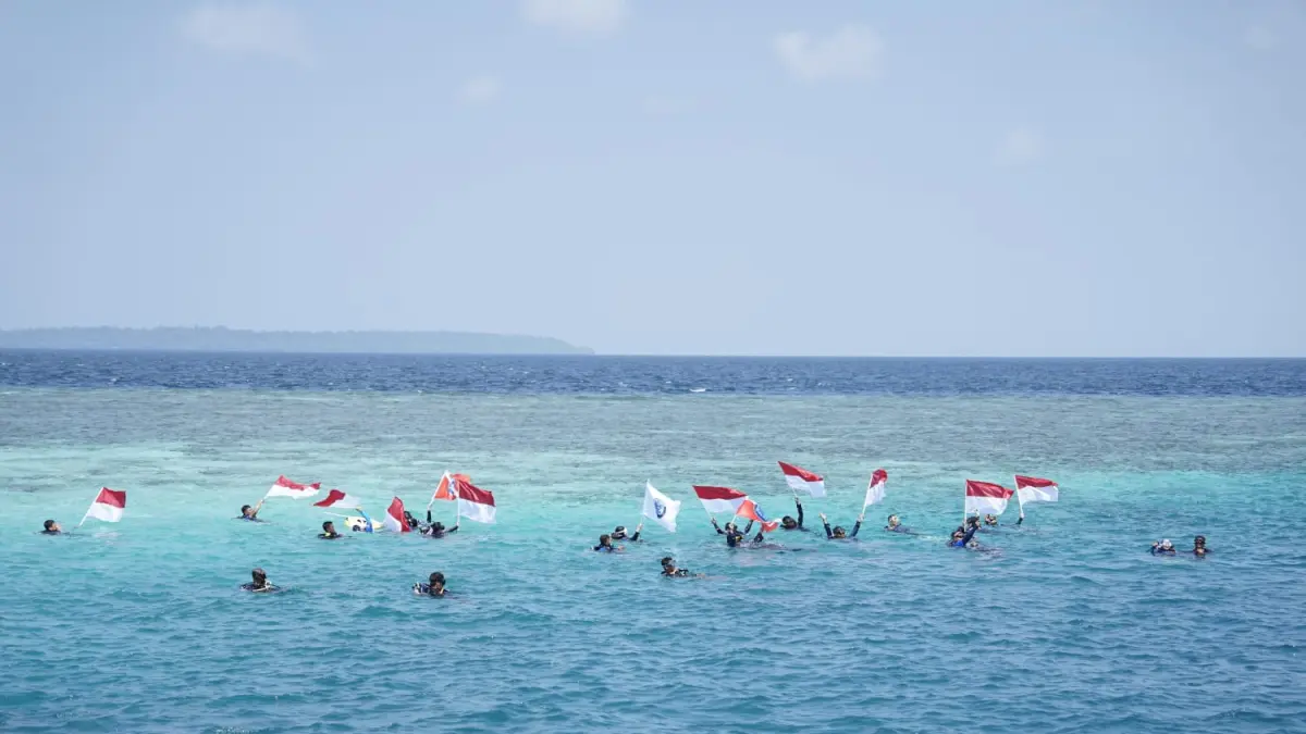 SIMBOL NASIONALISME: Komunitas selam di Berau melaksanakan pengibaran bendera di bawah laut Pulau Maratua, merupakan psalah satu pulau terluar di Indonesia, untuk memperingati HUT ke-81 Republik Indonesia. (AGUS UNTUK BERAU POST)