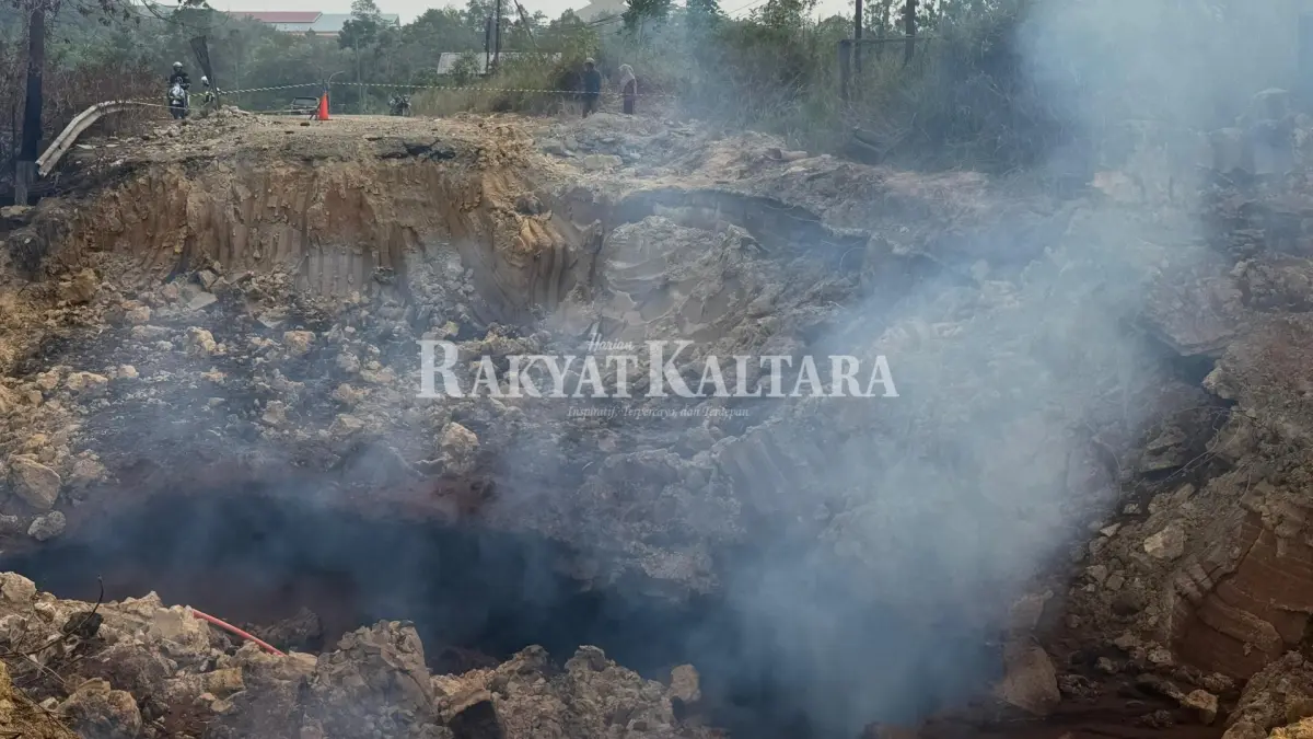 MASIH TERBAKAR: Material batu bara masih terbakar dan mengeluarkan asap di jalan Kelurahan Pantai Amal, Rabu (2/9). (SEPTIAN ASMADI/HRK)