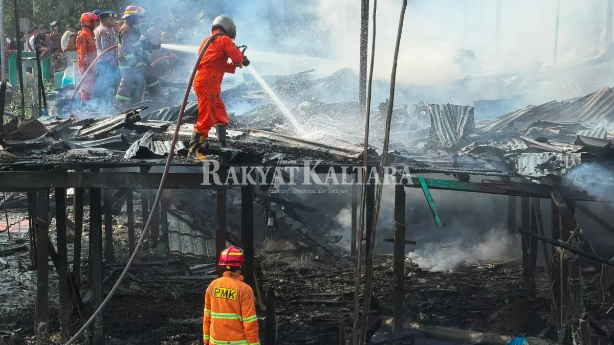 PENDINGINAN: Sejumlah warga berjibaku untuk memadamkan amukan si jago merah. Petugas pemadam kebakaran mendinginkan rumah yang terbakar, Jumat (18/9). (SEPTIAN ASMADI/HRK)