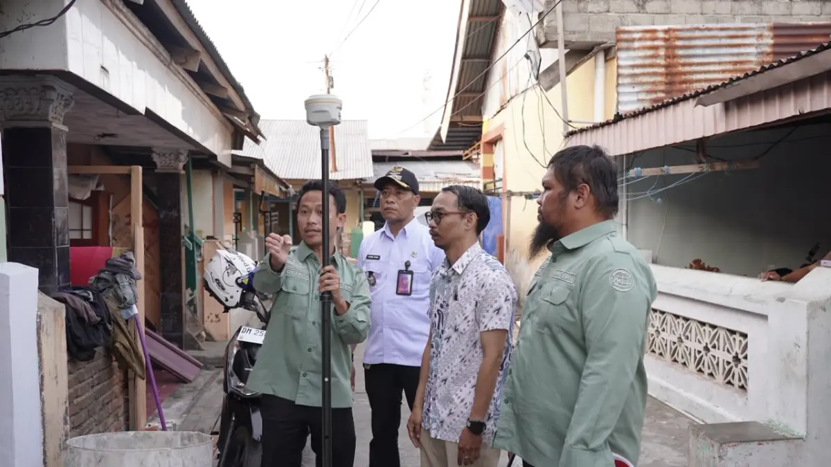 LAYANAN PENGUKURAN TERJADWAL: Petugas Kantor Pertanahan melakukan pengukuran bidang tanah yang disaksikan aparatur kelurahan dan PPAT di Kota Gorontalo melalui penerapan inovasi layanan Pengukuran Terjadwal yang memberikan kepastian waktu kepada pemohon