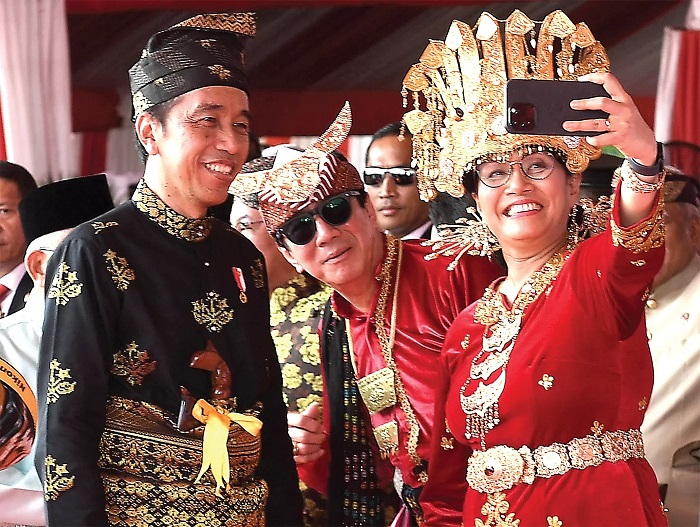 KENAKAN PAKAIAN ADAT: Jokowi bersama Sri Mulyani berswafoto di sela upacara Hari Lahir Pancasila di kawasan Monas, Jakarta, Kamis (1/6).