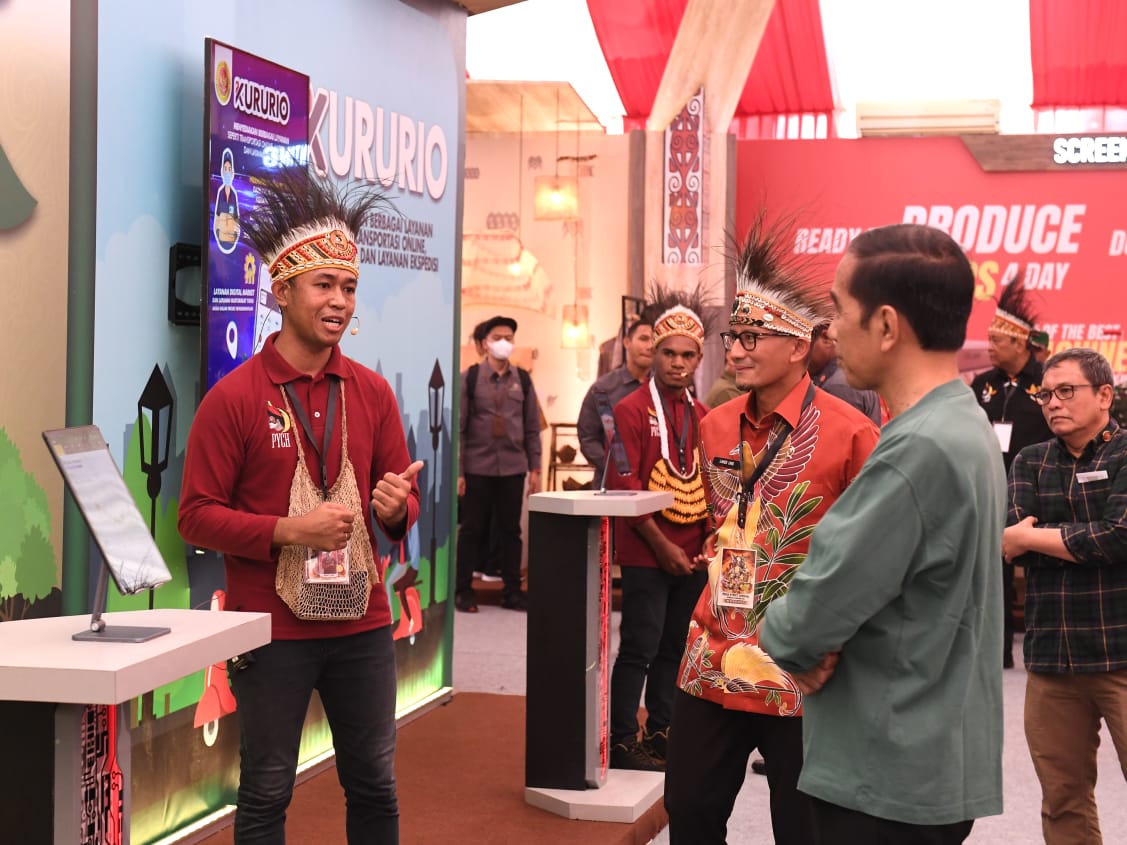 Presiden Jokowi saat menyimak presentasi Irsanto Imbiri, Manajer Implementasi Papua untuk Containder, di dalam kegiatan Papua Street Carnival, Jumat (7/7).