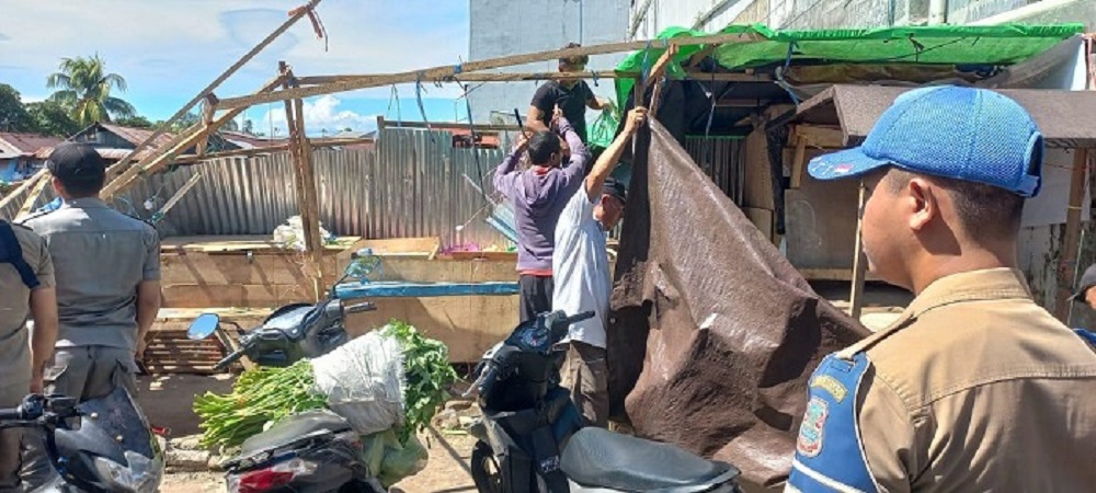 Personel Satpol PP Kota Manado dan pihak kepolisian mengamankan proses berjalannya pengambilalihan lahan Eks Pasar Tuminting oleh Ahli Waris Mongie Abuthan.