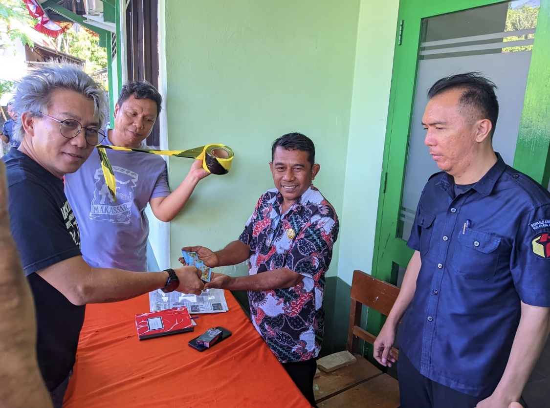 Sekelompok aktivis menyerahkan obat masuk angin kepada Pimpinan Bawaslu Minut Ferdynand Bawengan serta Sekretaris Bawaslu Minut Maikel Poli di depan kantor, Senin (4/8/2023).
