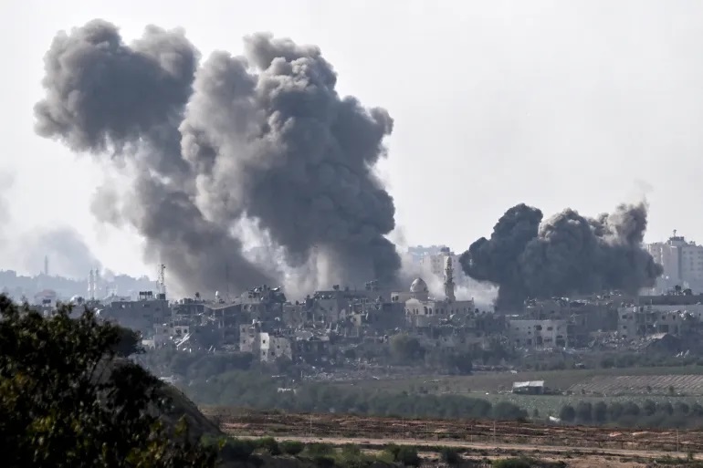 Gumpalan asap membubung di atas gedung-gedung selama serangan Israel di Jalur Gaza utara pada 14 Oktober 2023 (Aris Messinis/AFP)